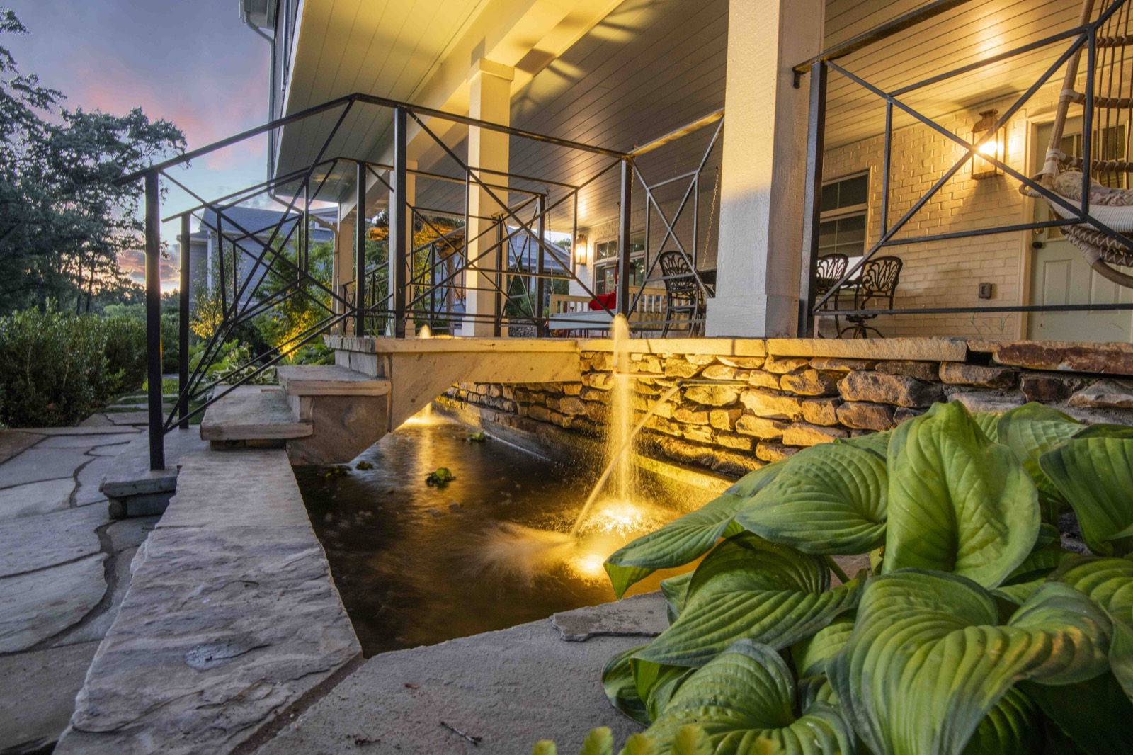 Modern back exterior of a custom home with covered deck and stone work