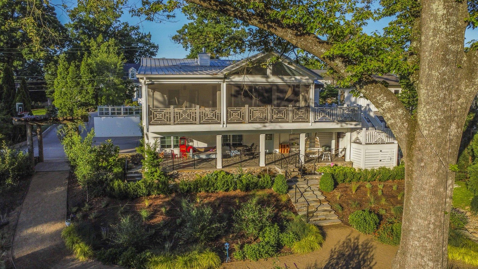 Aerial view of the renovated home, screened porch, and terraced gardens