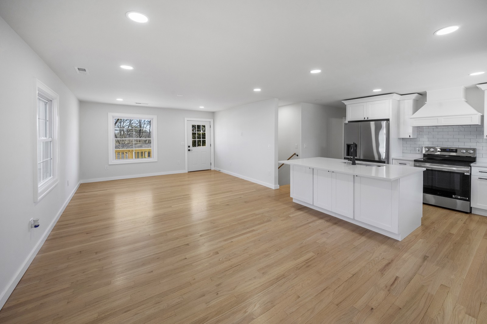 Renovated open-concept kitchen and living area with oak floors