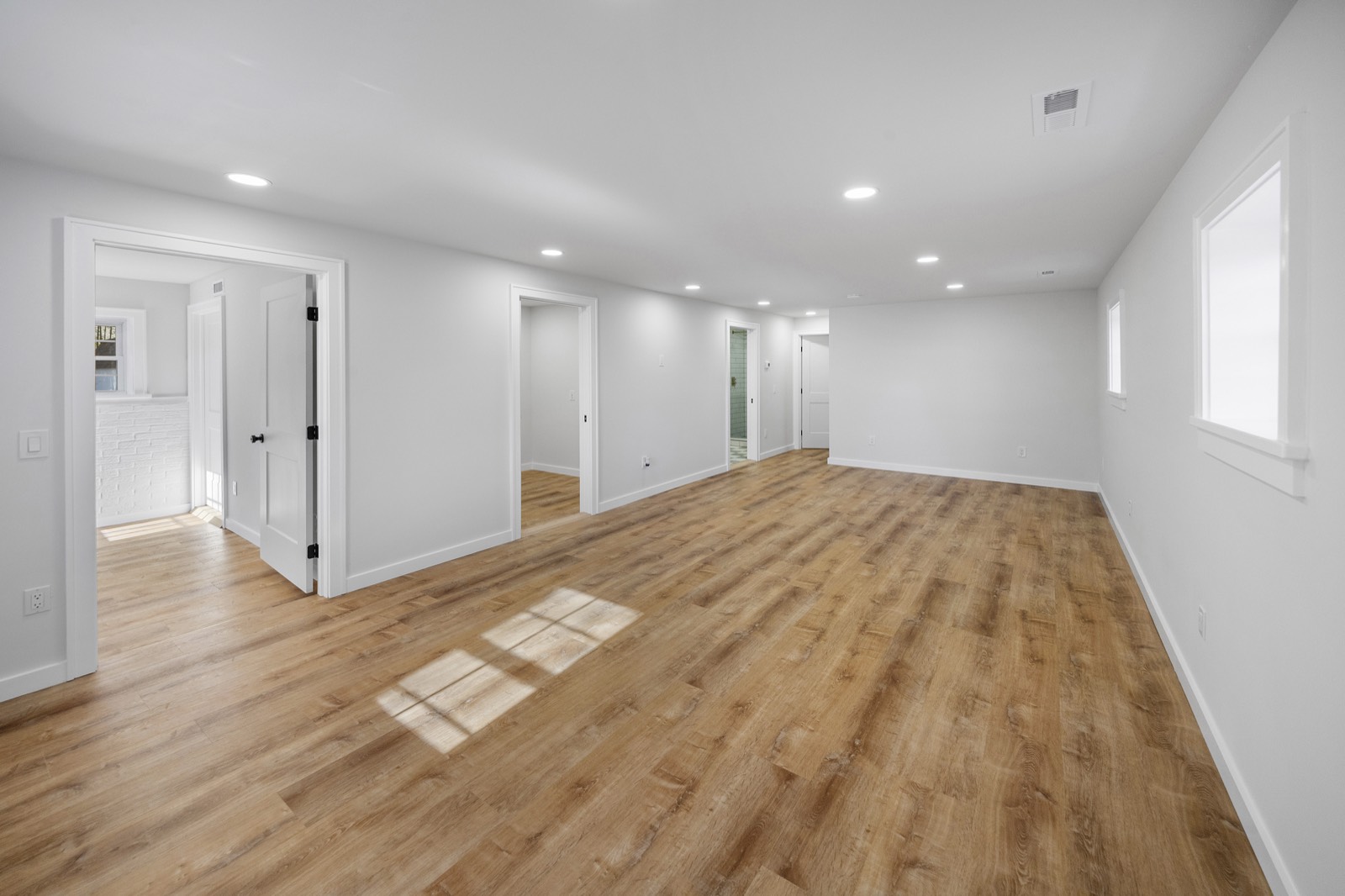 Open living space with recessed lighting and warm oak flooring