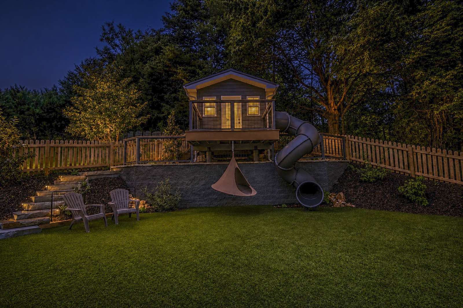 Gardens and pathways glowing under landscape lighting at twilight