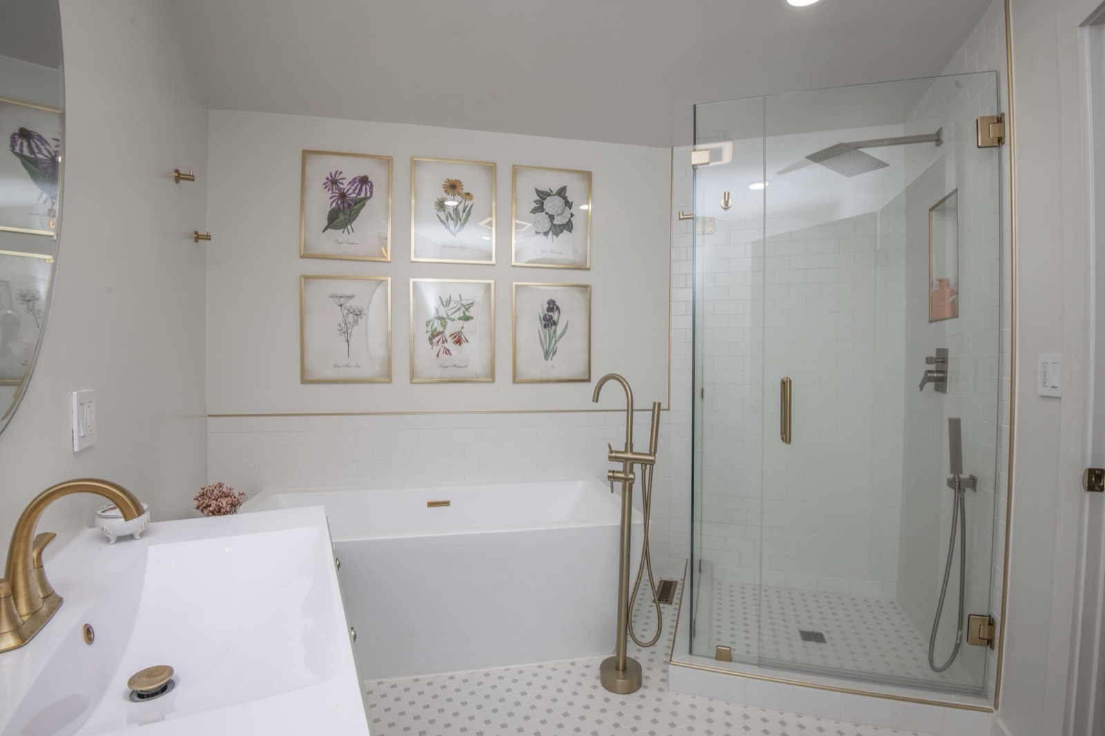 Bright bath with a freestanding soaking tub, glass shower, and brass fixtures