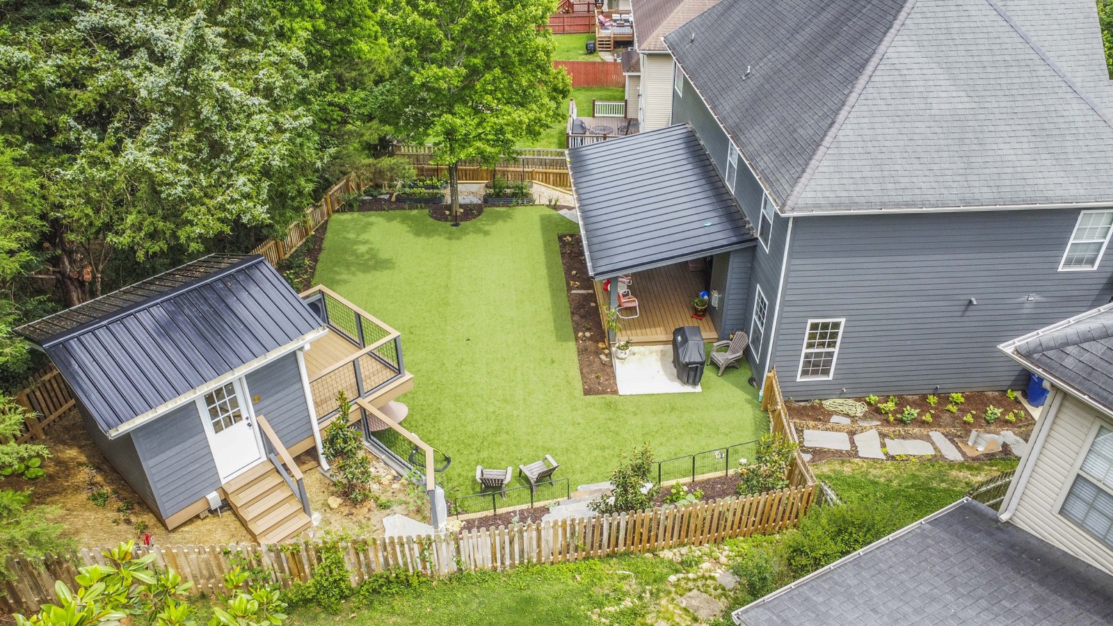 Aerial of the turf play lawn, playhouse, covered patio, and garden beds