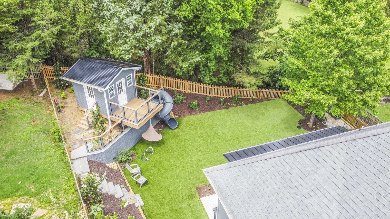 Overhead view of the custom playhouse, spiral slide, and turf play lawn